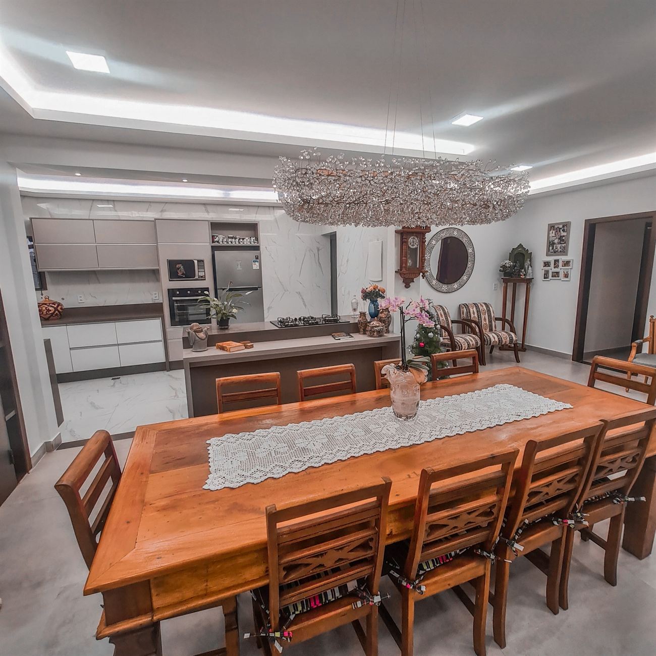 Sala de jantar integrada com lustre de cristal